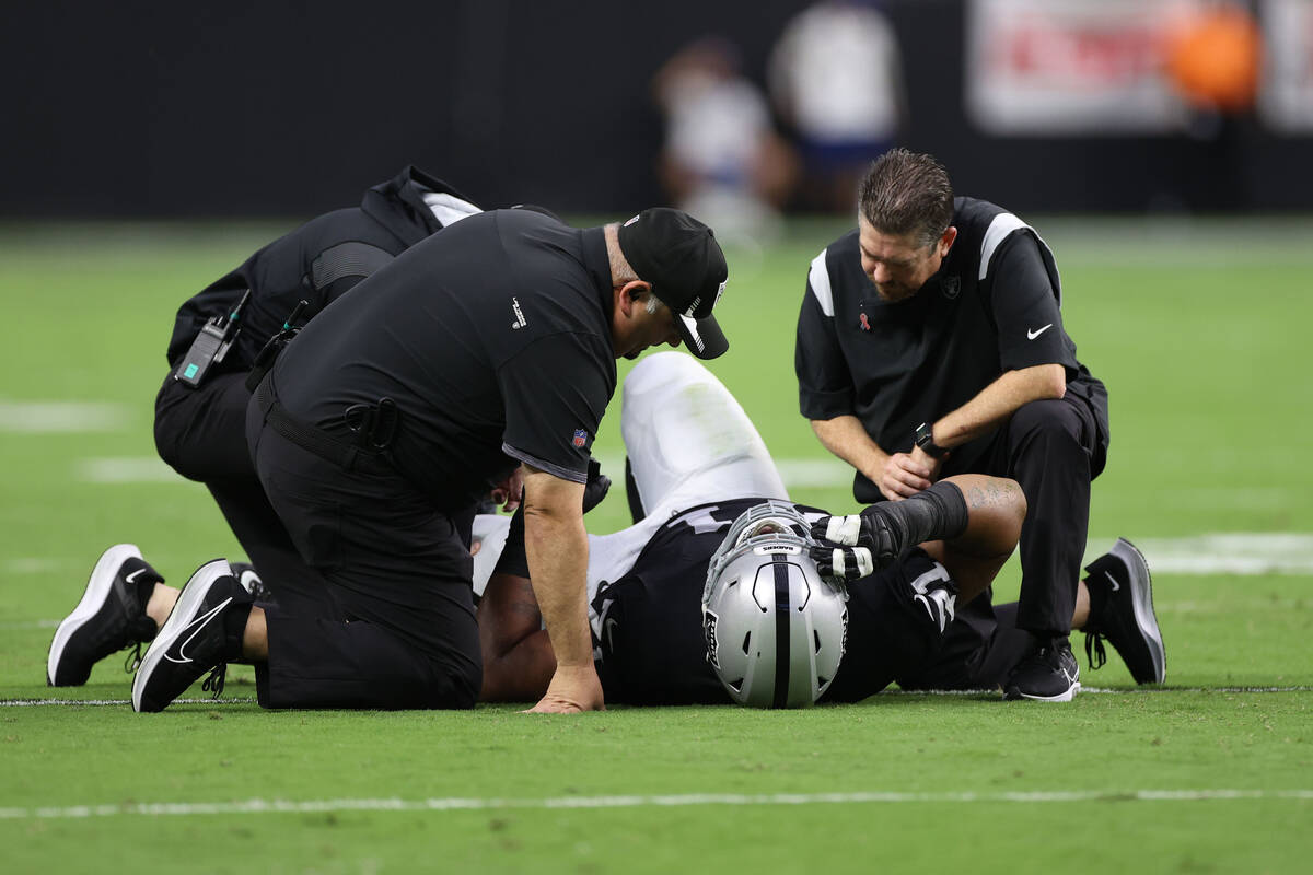 Las Vegas Raiders offensive guard Denzelle Good (71) lies on the field after getting injured ag ...