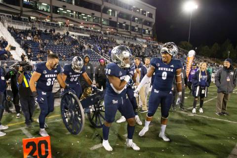 The Nevada team brings the Fremont Cannon onto the field after their win over UNLV in an NCAA c ...