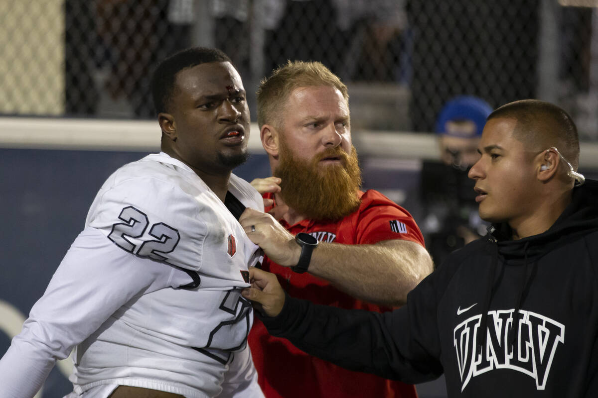 UNLV's Brennon Scott (22) is held back by team members after being call for a personal foul aga ...