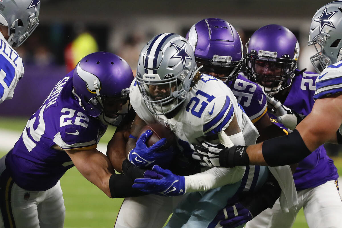 Dallas Cowboys running back Ezekiel Elliott (21) is tackled by Minnesota Vikings safety Harriso ...