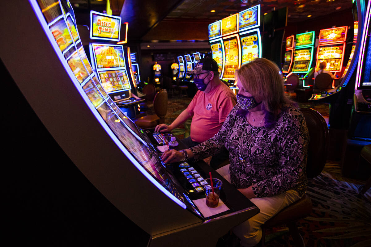 Markland Davis, left, and Mary Anne Davis, both of Maryland, play slot machines during their st ...
