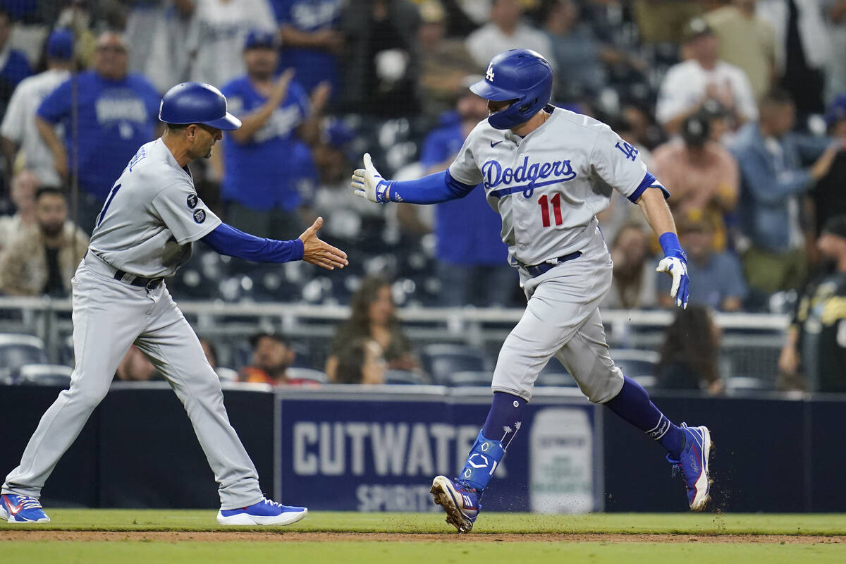 Los Angeles Dodgers' AJ Pollock, right, reacts with third base coach Dino Ebel after hitting a ...