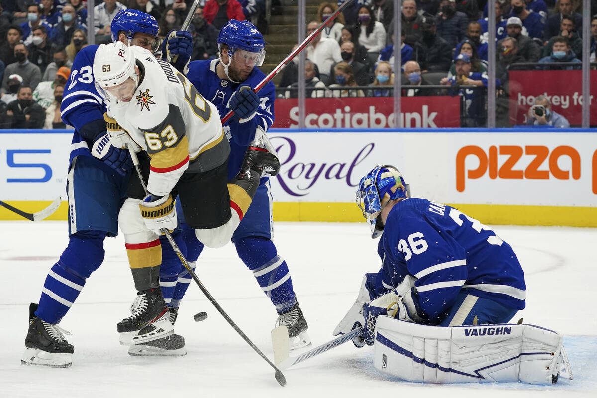 Vegas Golden Knights forward Evgenii Dadonov (63) deflects the puck next to Toronto Maple Leafs ...