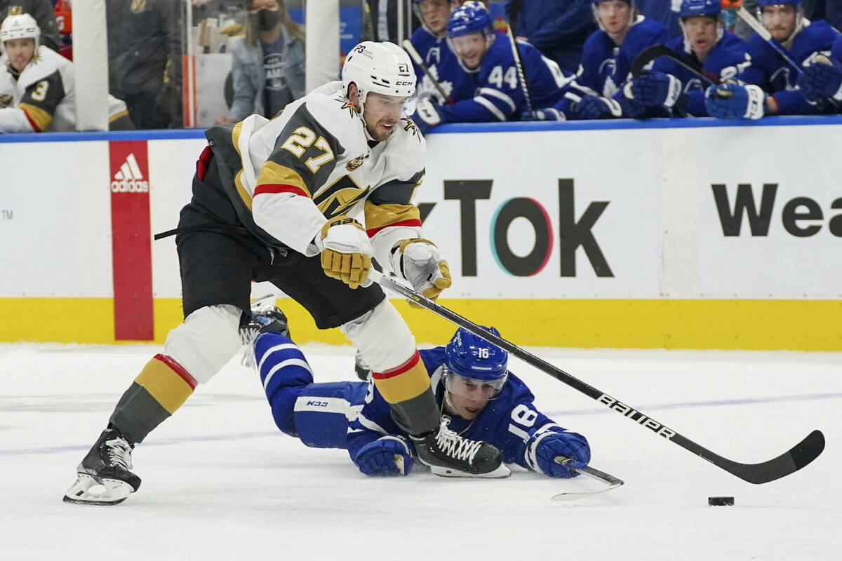 Vegas Golden Knights defenseman Shea Theodore (27) loses the puck after a diving poke-check by ...
