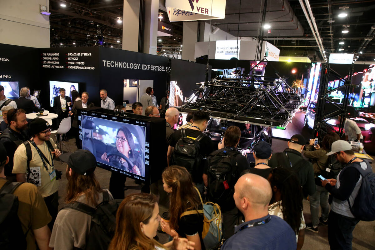 A conventioneer checks out an "enhanced environment" inside a car in the production equipment a ...