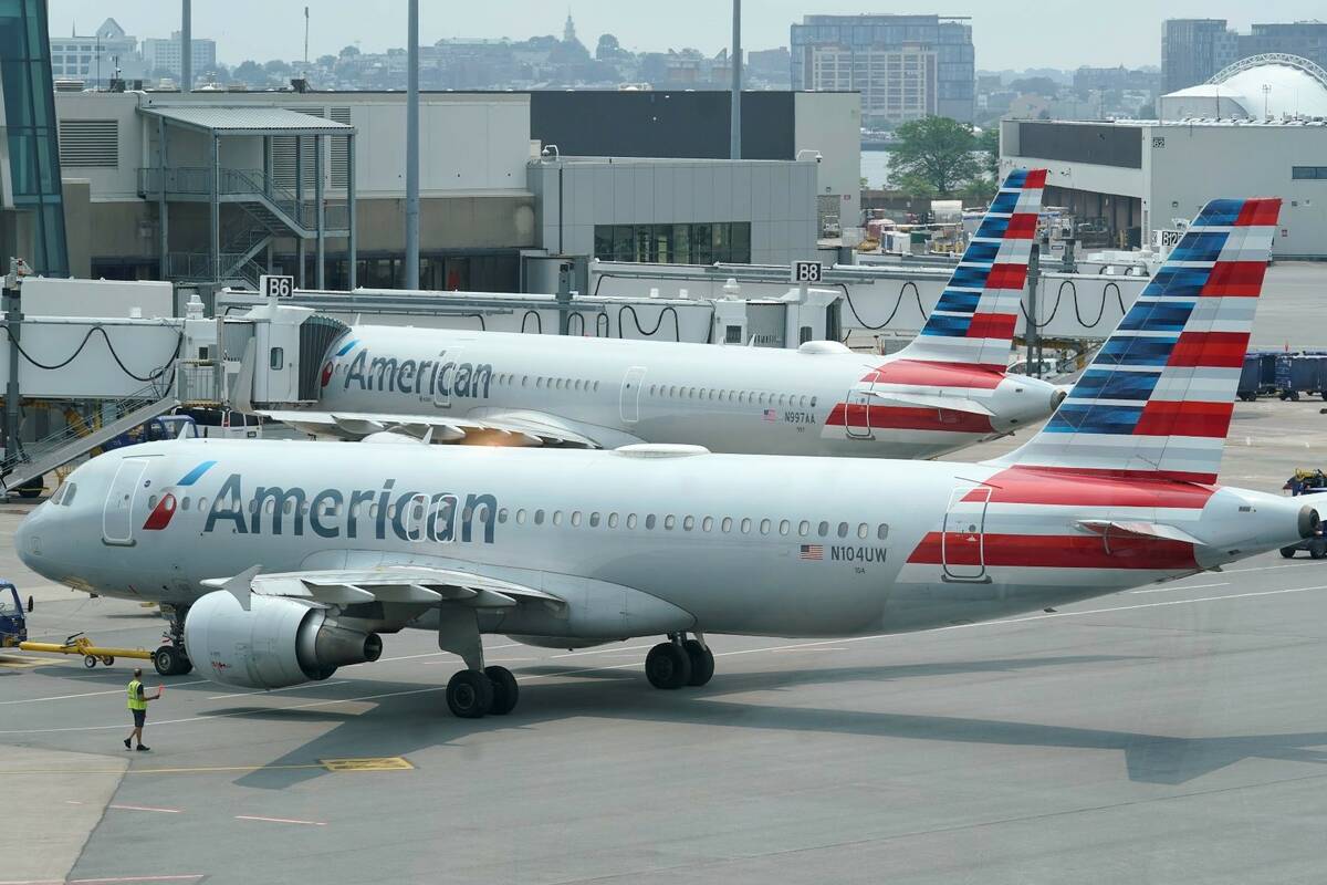 American Airlines passenger jets prepare for departure near a terminal at Boston Logan Internat ...
