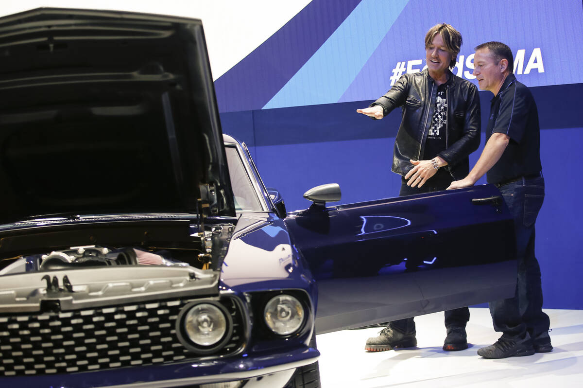 Country music star Keith Urban, left, checks out his renovated 1969 Ford Mustang with Dave Peri ...