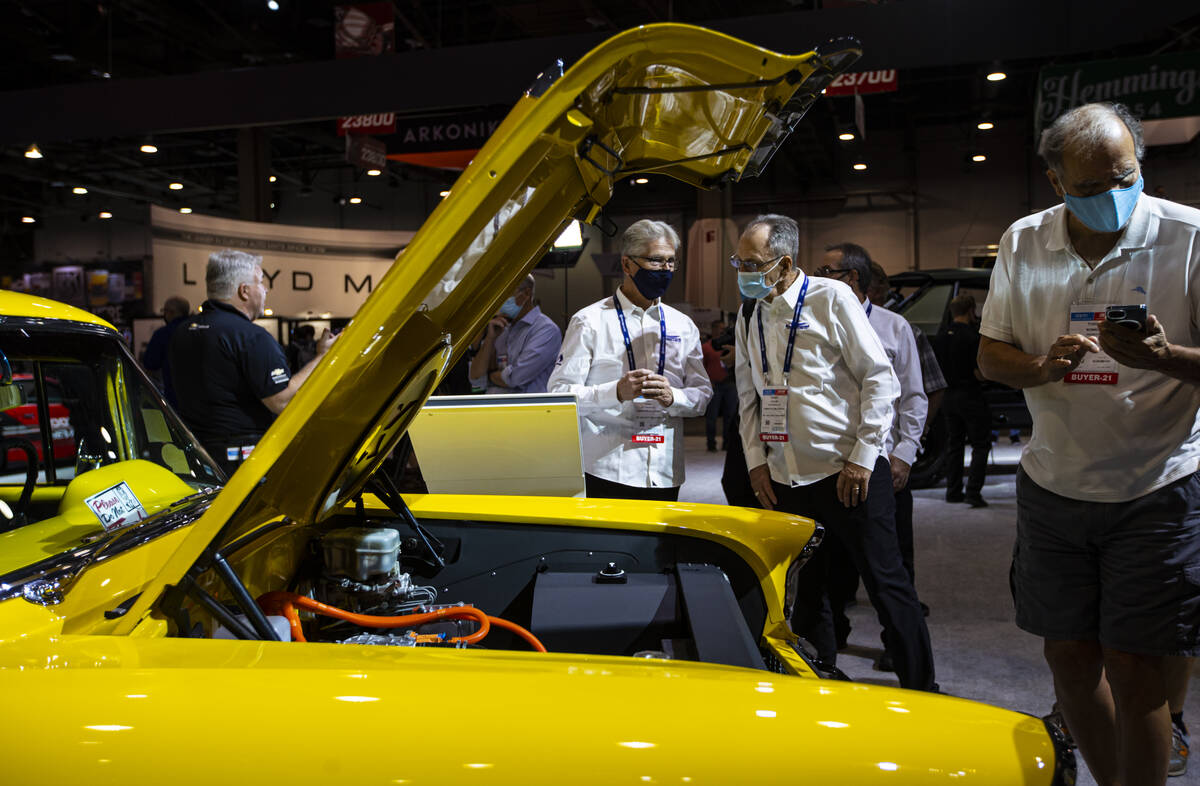 Ian Foss, left, and Grant Taylor, both of Canada check out an all-electric 1957 Chevy Bel Air 2 ...