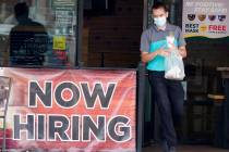 In this Sept. 2, 2020, file photo, a customer wears a face mask as they carry their order past ...