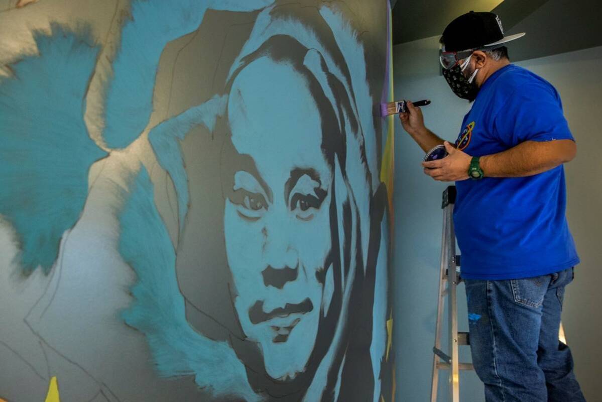 Artist Miguel Hernandez paints a mural in memory of Tony Hsieh in the lobby of ART HOUZ Theater ...