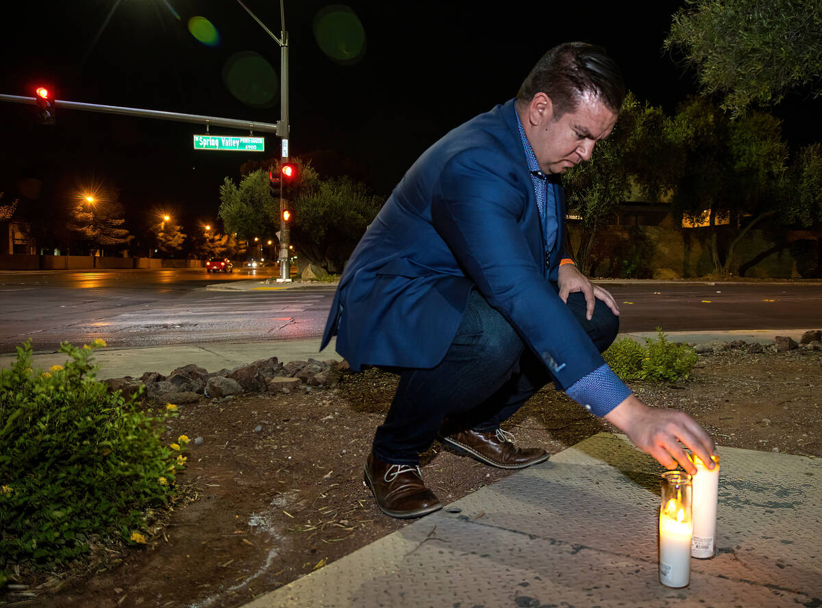Andrew Bennett, program director for the state's Zero Fatalities, leaves a lighted candle near ...