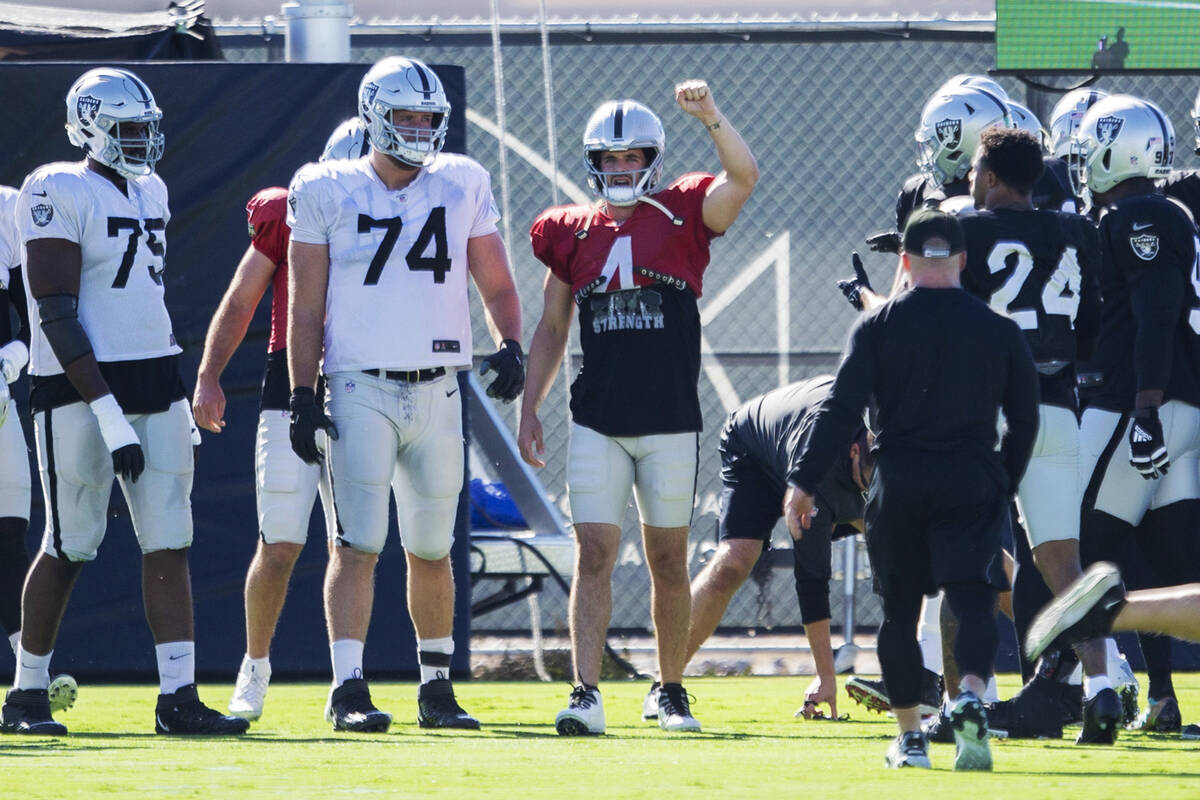 Raiders quarterback Derek Carr (4) raises his fist as players come to a huddle during a practic ...