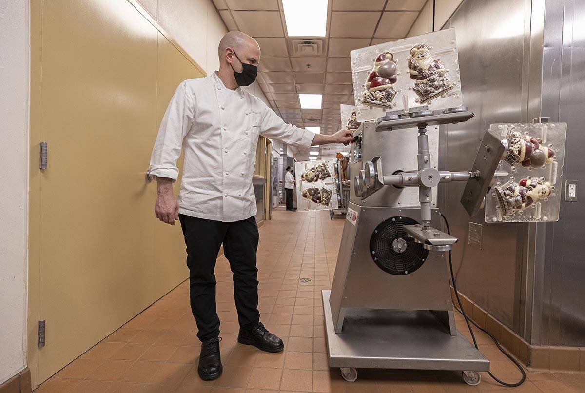 Executive pastry chef Mathieu Lavallee runs a pastry machine that evenly applies chocolate to S ...