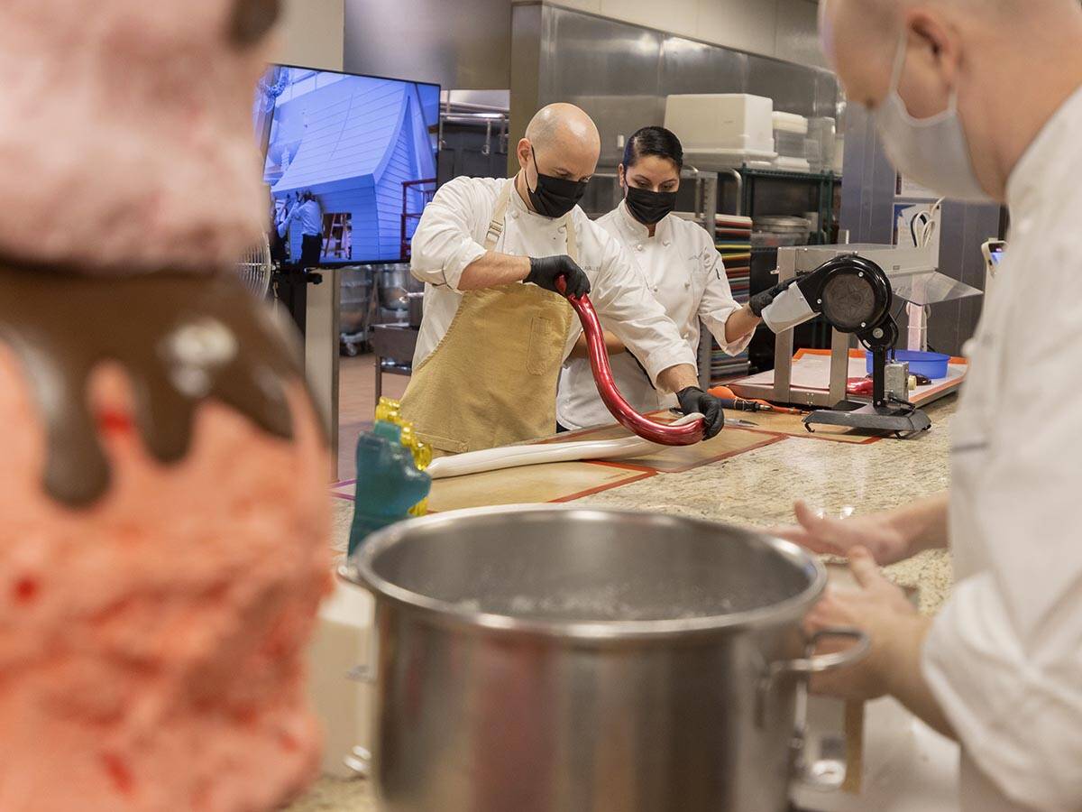 Executive pastry chef Mathieu Lavallee, top/left, shapes a giant candy cane while preparing for ...