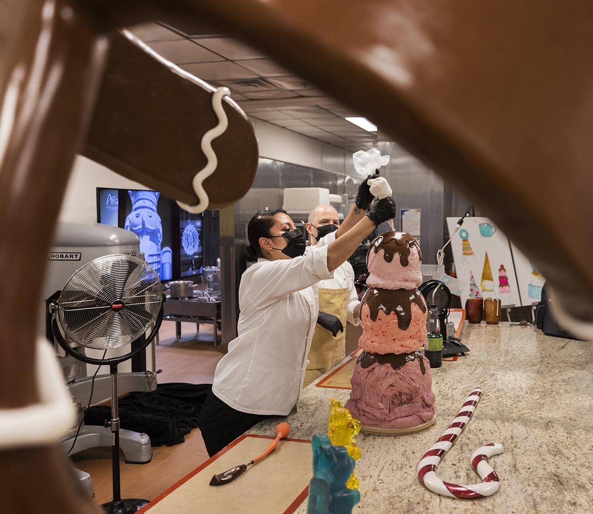 Assistant pastry chef Andrea Madrid applies icing to a giant ice cream cone while preparing for ...