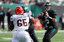 New York Jets quarterback Mike White, right, looks to throw during the first half of an NFL foo ...