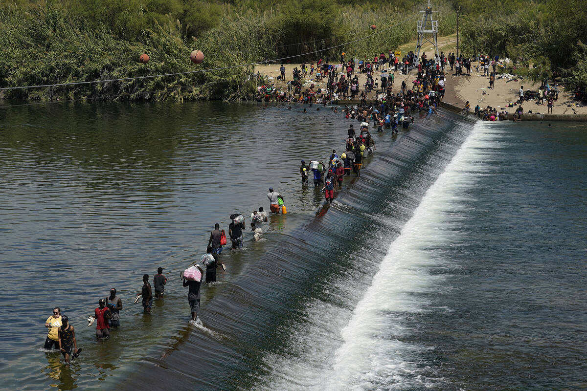 FILE - In this Sept. 18, 2021, file photo Haitian migrants use a dam to cross into the United S ...