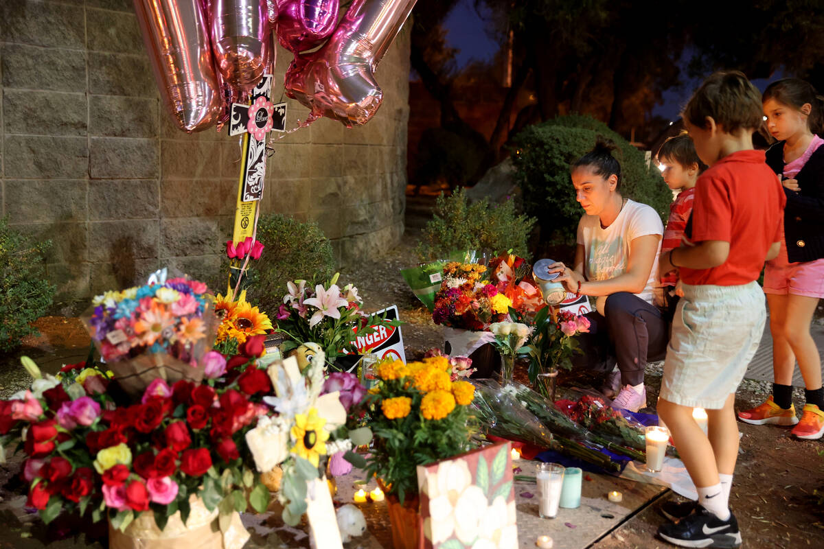 Close family friends of Tina Tintor, who declined to give their names, light candles at a her m ...