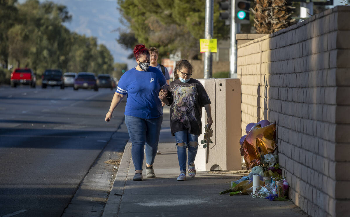 Genevicia Lopez with daughter Alexandra, 10, come to lay a cross at a roadside memorial near Ra ...