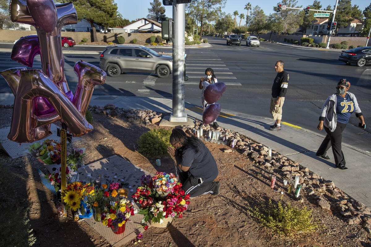 Johnesha Gilbert, center, brings pink balloons to leave at a roadside memorial for Tina Tintor ...