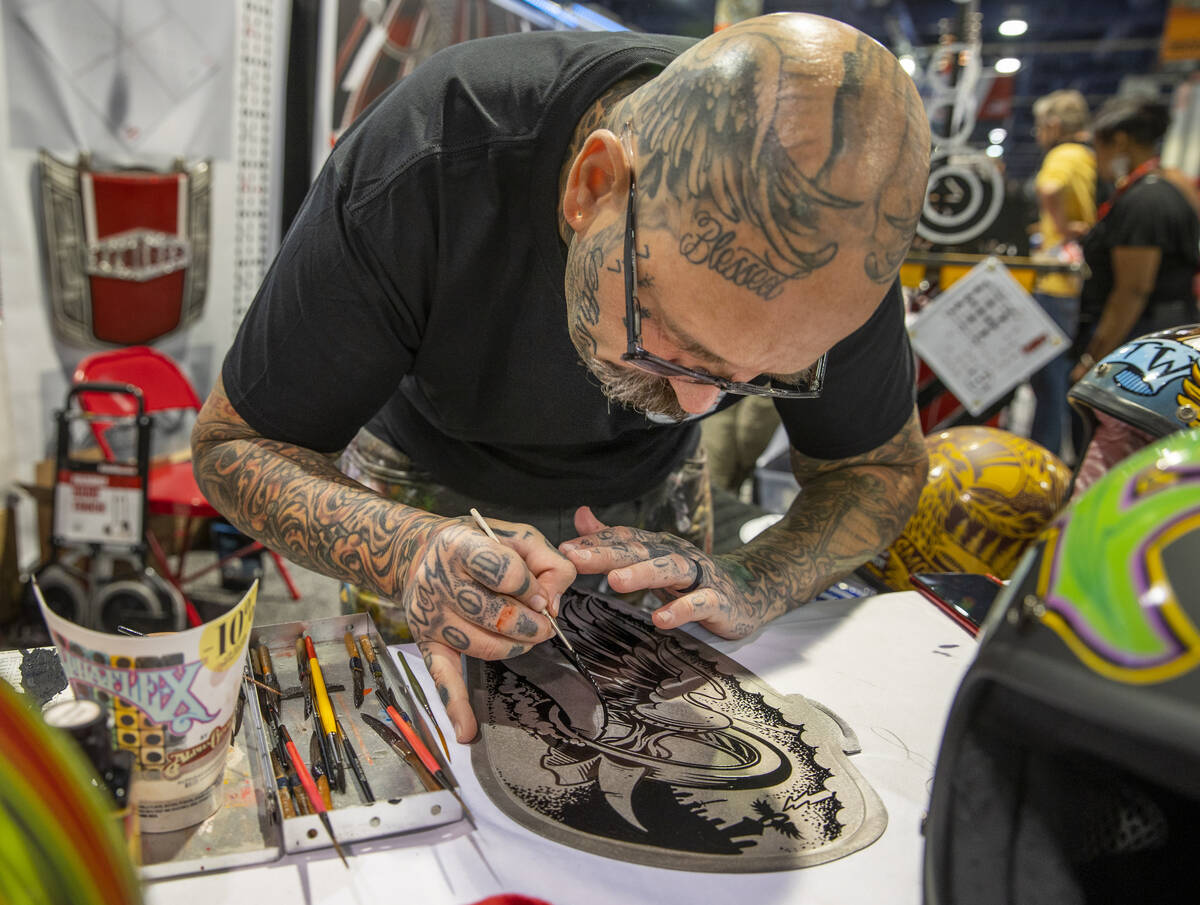 Artist Darren McKeag from McKeag Art creates another custom piece during SEMA at the Las Vegas ...