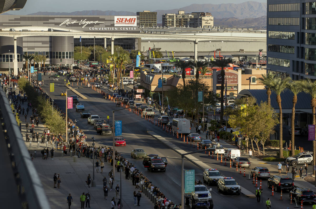 Vehicles cruise along East Convention Center Drive past the crowd during the car Cruise for SEM ...