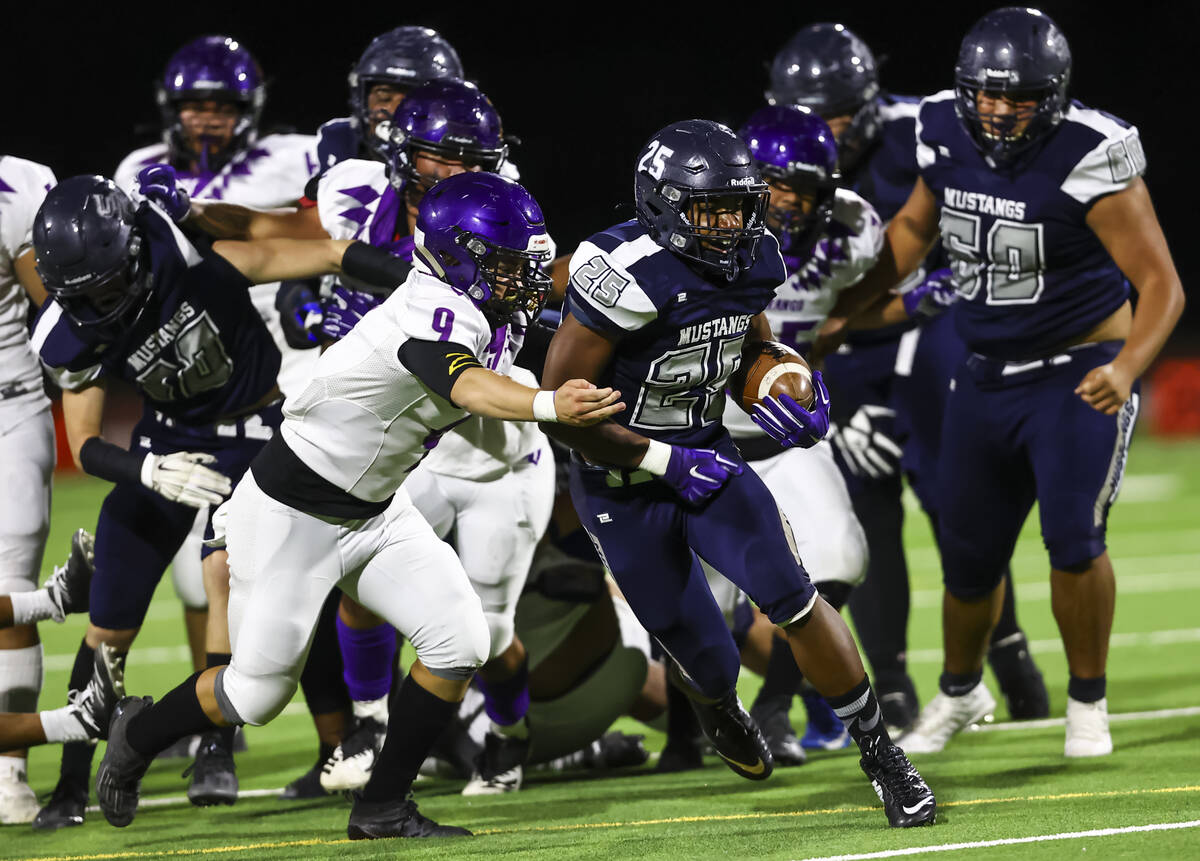 Shadow Ridge's Jaquieze Holland (25) runs the ball under pressure from Durango's Cole Marquez ( ...