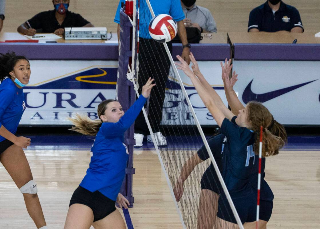 Bisho Gorman's Kendall Allgower (12) kills the ball while Centennial's Zoey Bonds (1) and Laura ...