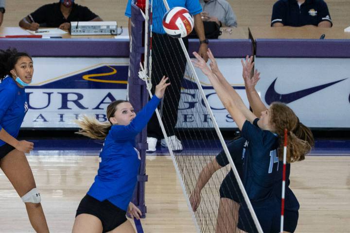 Bisho Gorman's Kendall Allgower (12) kills the ball while Centennial's Zoey Bonds (1) and Laura ...