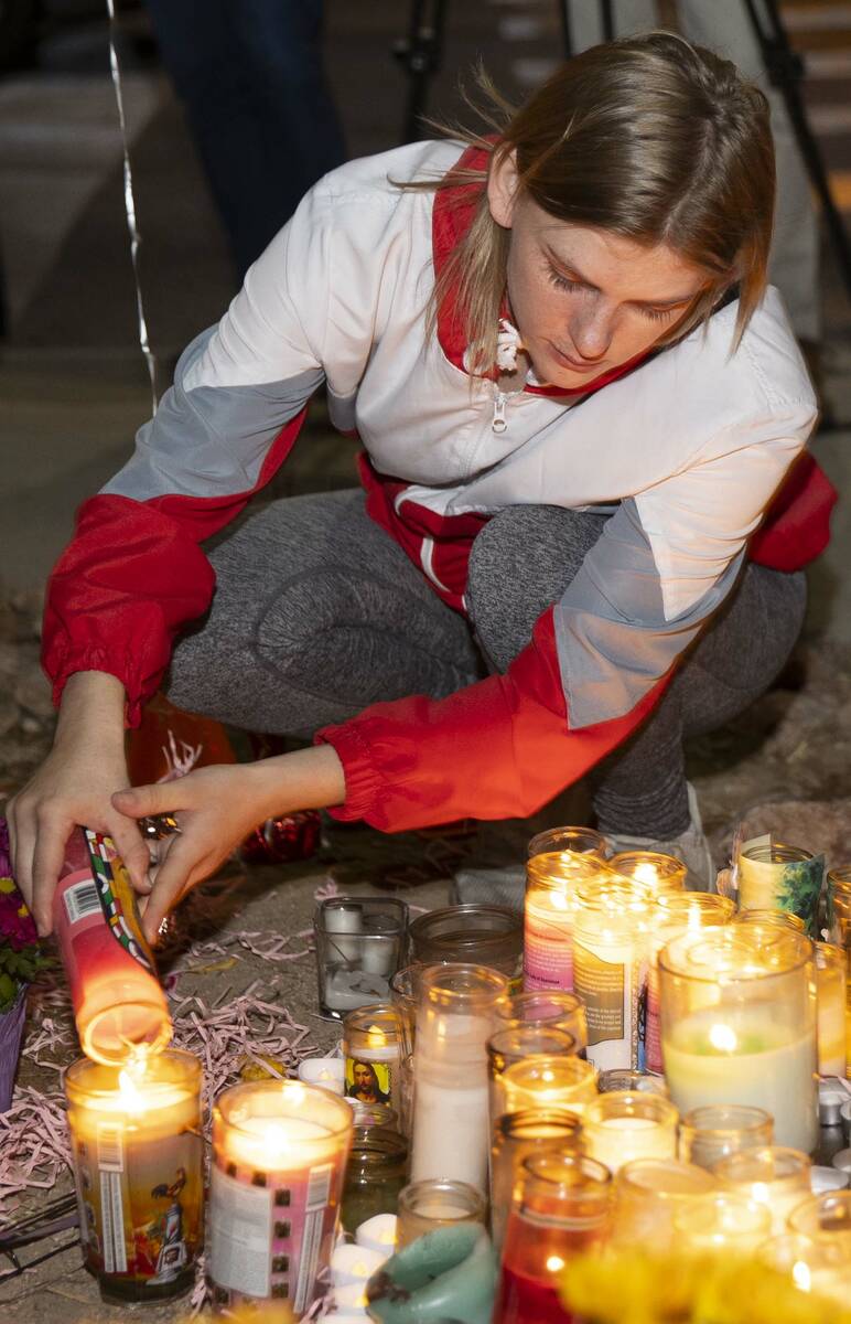 Jordan Vogl-Rees lights up a candle during a vigil for her coworker Tina Tintor and her dog Max ...
