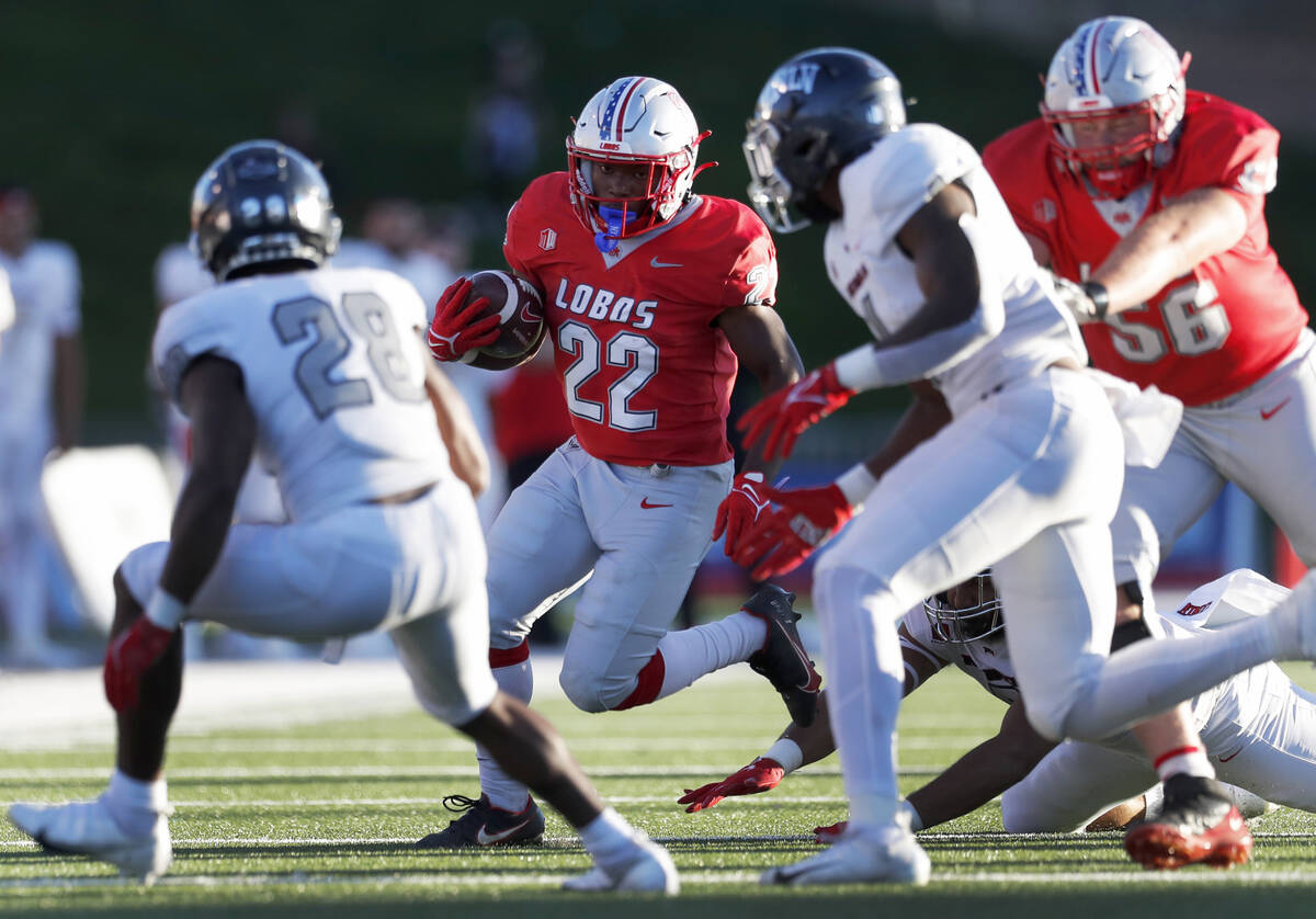 New Mexico running back Aaron Dumas (22) is slowed by the UNLV defense during the first half of ...