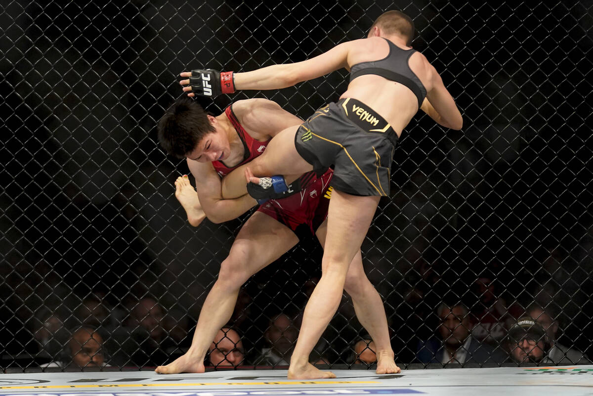 Weili Zhang tries to take down Rose Namajunas during a straw weight mixed martial arts champion ...