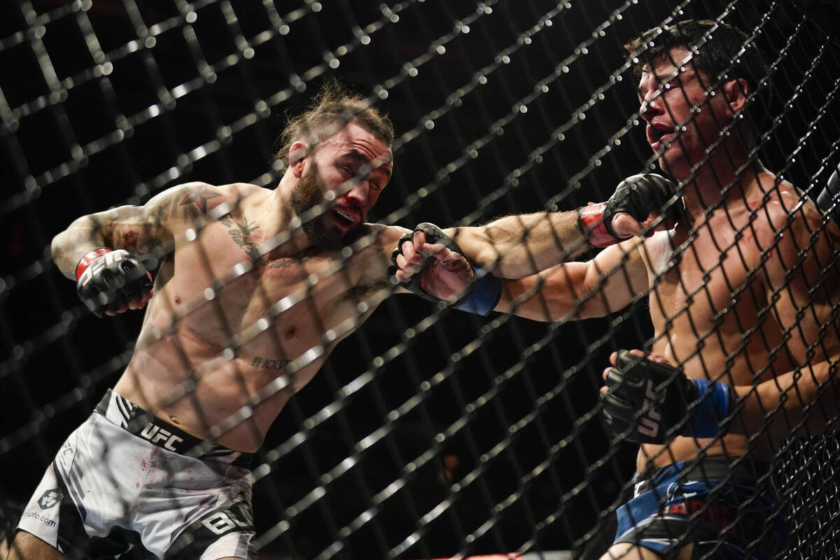 Shane Burgos lands a punch against Billy Quarantillo during a featherweight mixed martial arts ...