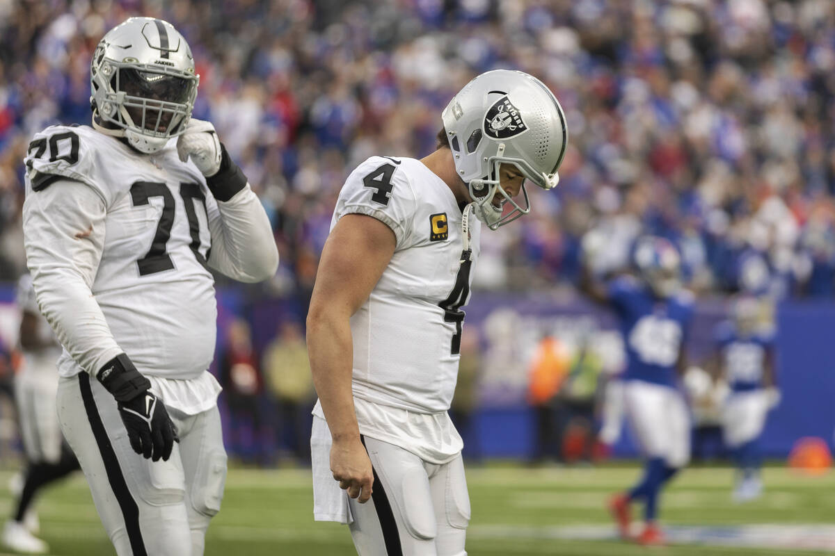 Las Vegas Raiders quarterback Derek Carr (4) looks dejected as he walks to the bench after thro ...