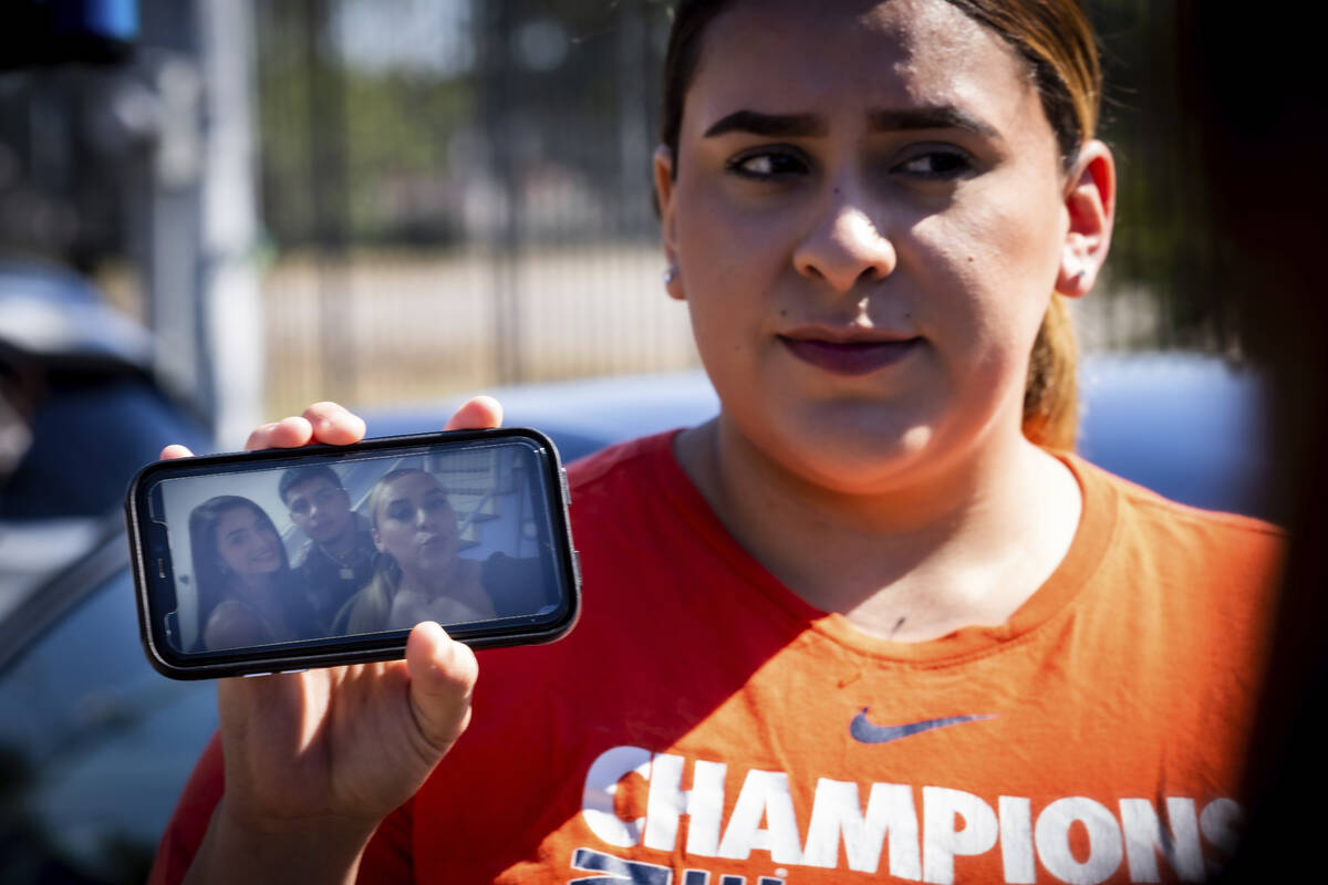 Stacey Sarmiento holds a photo up of her posing with her friend, Rudy Pena, who died in a crush ...