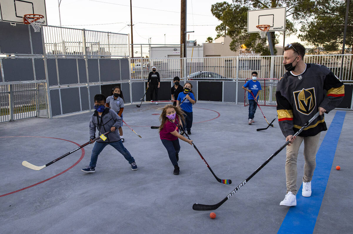 Newly acquired Golden Knights center Jack Eichel, right, plays with kids in a scrimmage match d ...