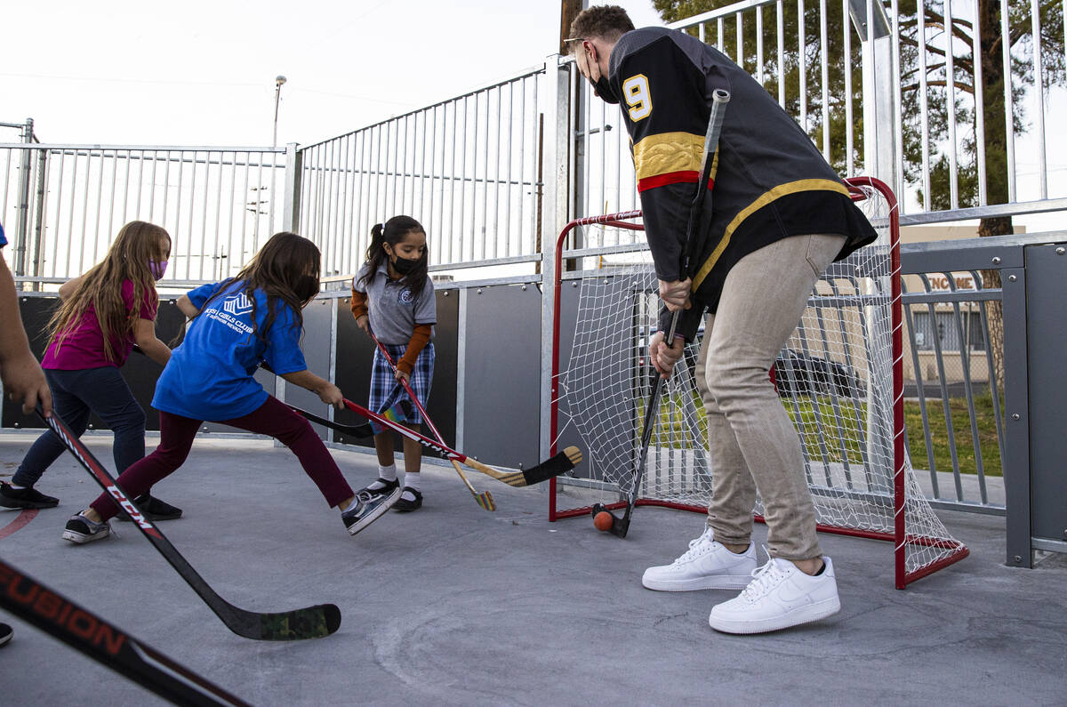 Newly acquired Golden Knights center Jack Eichel, right, defends the net against Sahely, 10, in ...