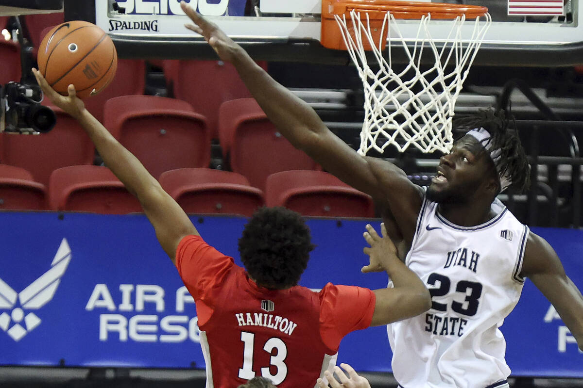 UNLV guard Bryce Hamilton (13) shoots as Utah State center Neemias Queta (23) defends during th ...