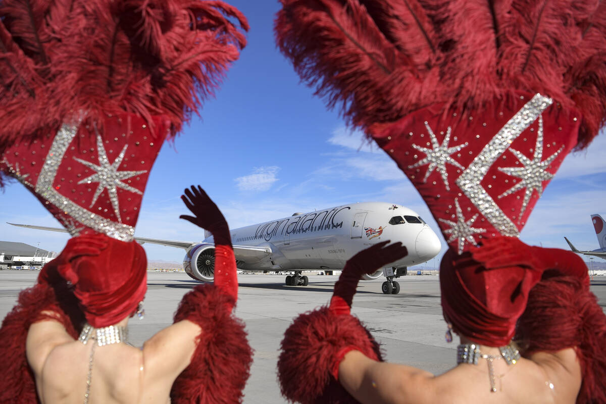 Showgirls wave as Virgin Atlantic Flight 155 from London Heathrow Airport arrives as the first ...