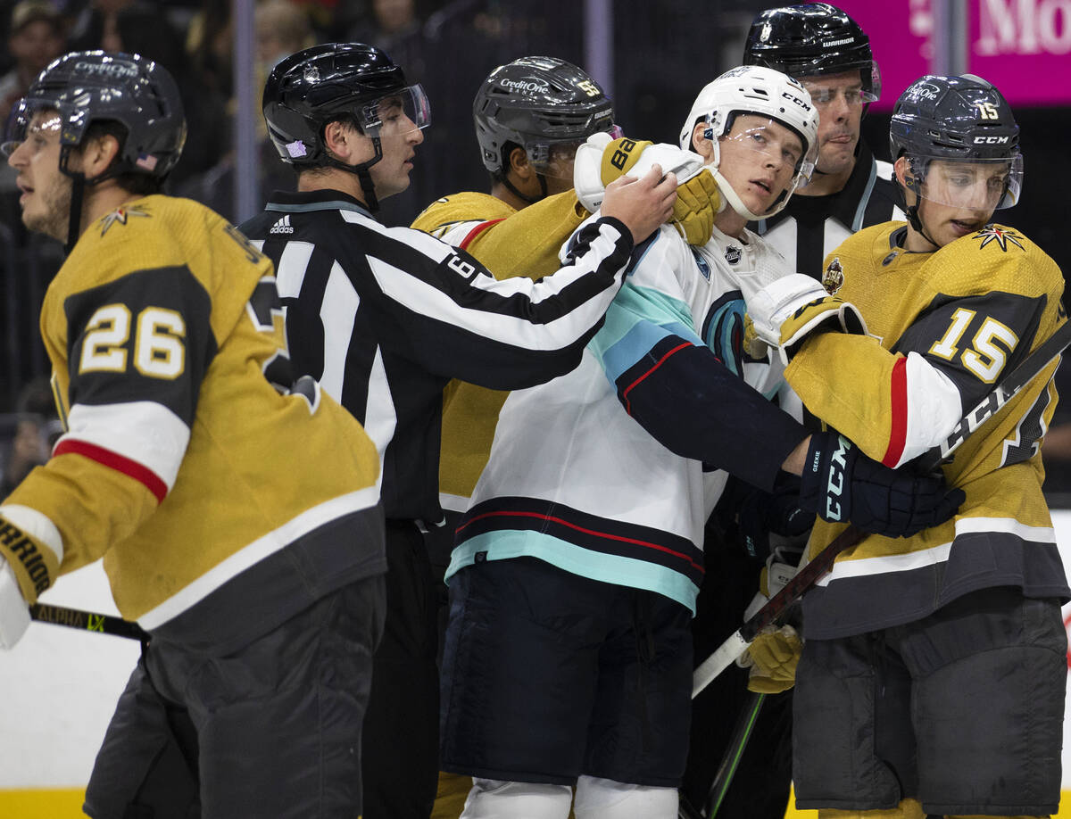 Seattle Kraken center Morgan Geekie (67) is locked up with Vegas Golden Knights center Jake Les ...
