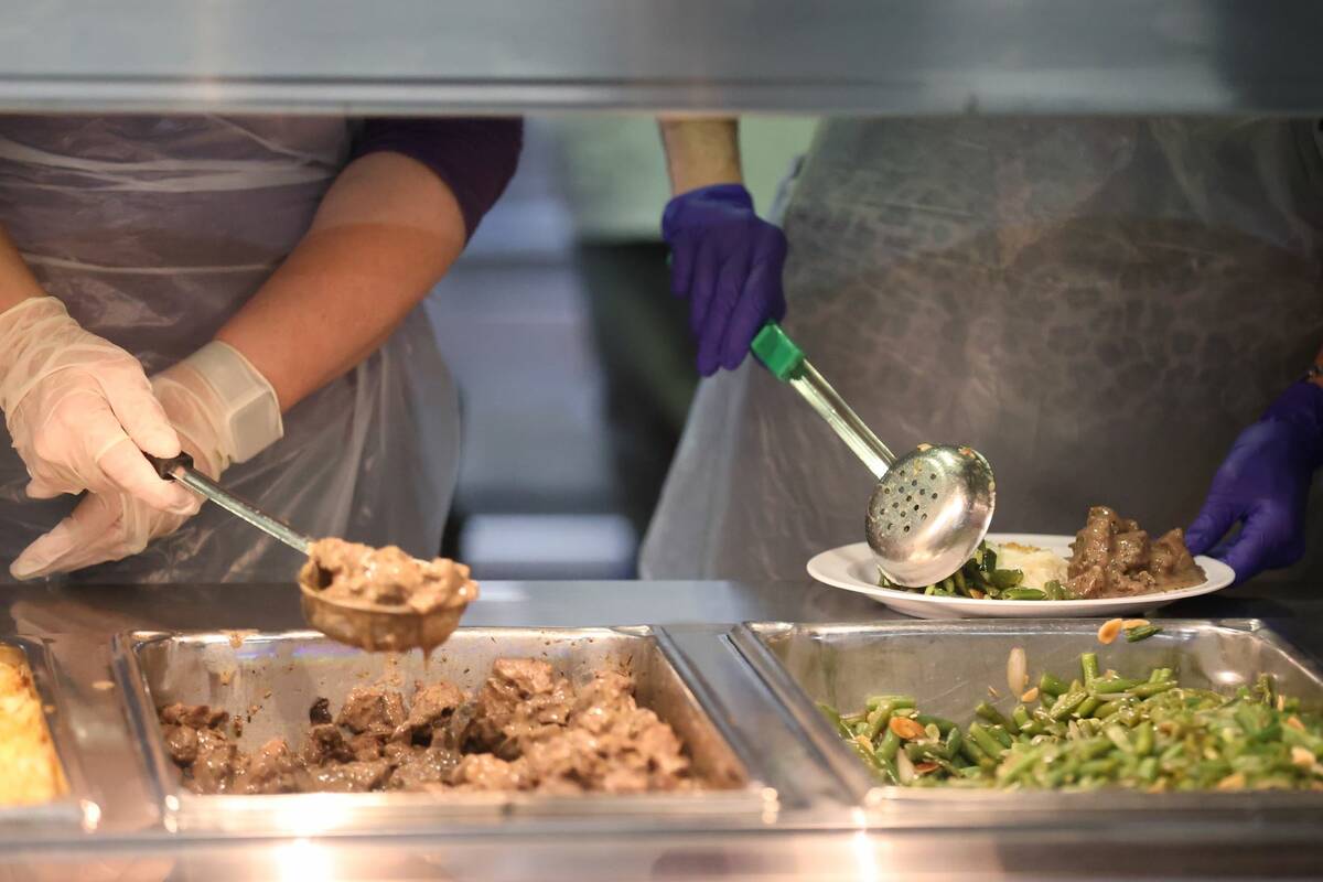 Volunteers Sara Ricciardi, left, and Kathleen Dussault, serve food to people during the reopeni ...