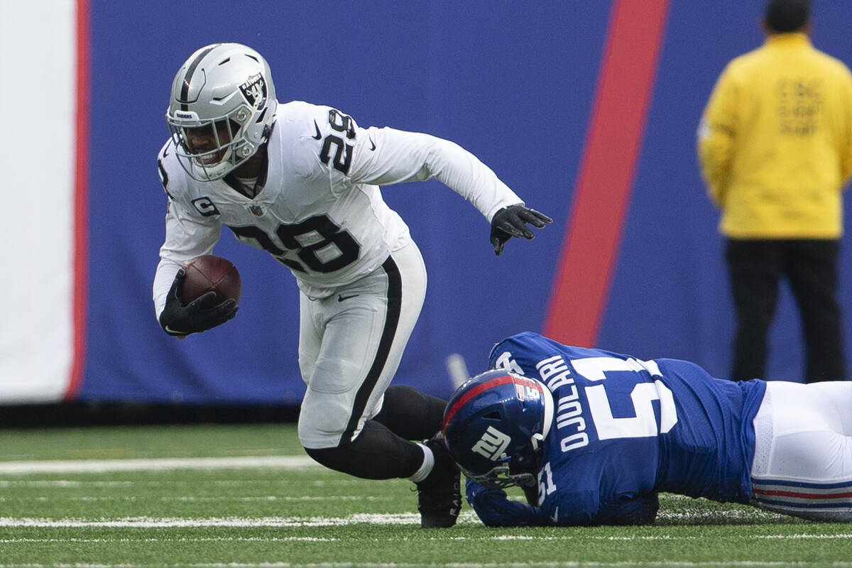 Las Vegas Raiders running back Josh Jacobs (28) sheds a tackle by New York Giants outside lineb ...