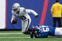 Las Vegas Raiders running back Josh Jacobs (28) sheds a tackle by New York Giants outside lineb ...