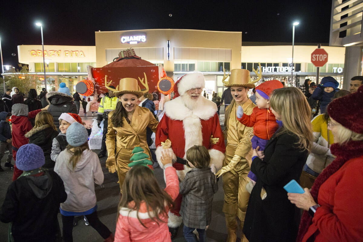 Santa is greeted by children as he walks down Festival Plaza Drive during the Downtown Summerli ...