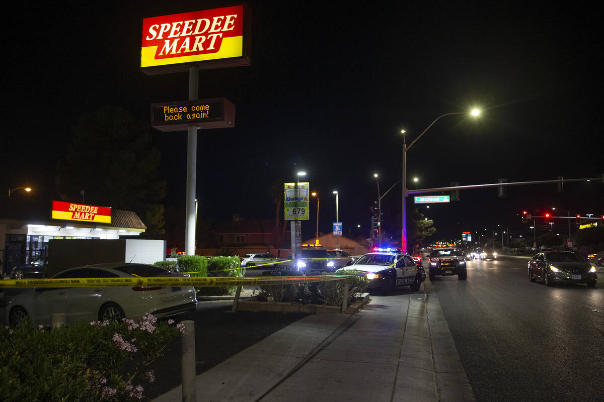 Metropolitan police investigate a homicide at a convenience store near the intersection of McLe ...