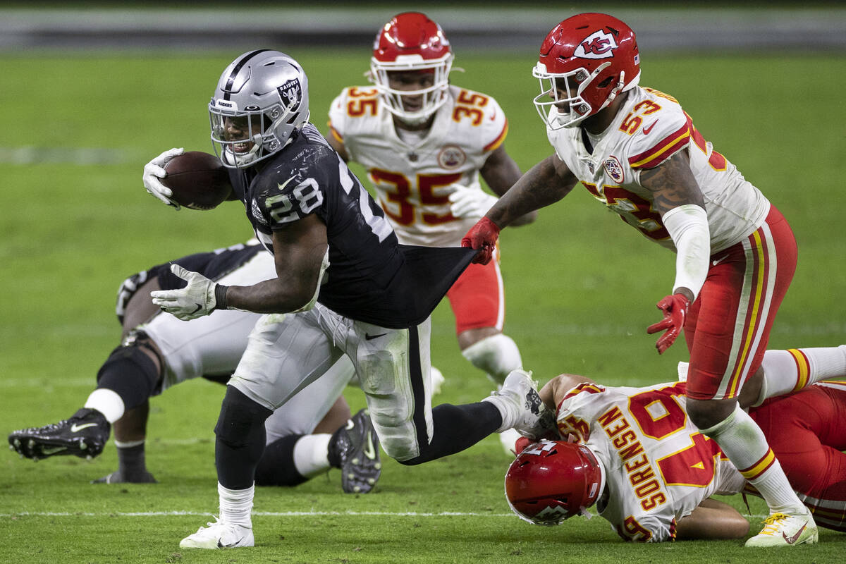 Las Vegas Raiders running back Josh Jacobs (28) runs past Kansas City Chiefs inside linebacker ...
