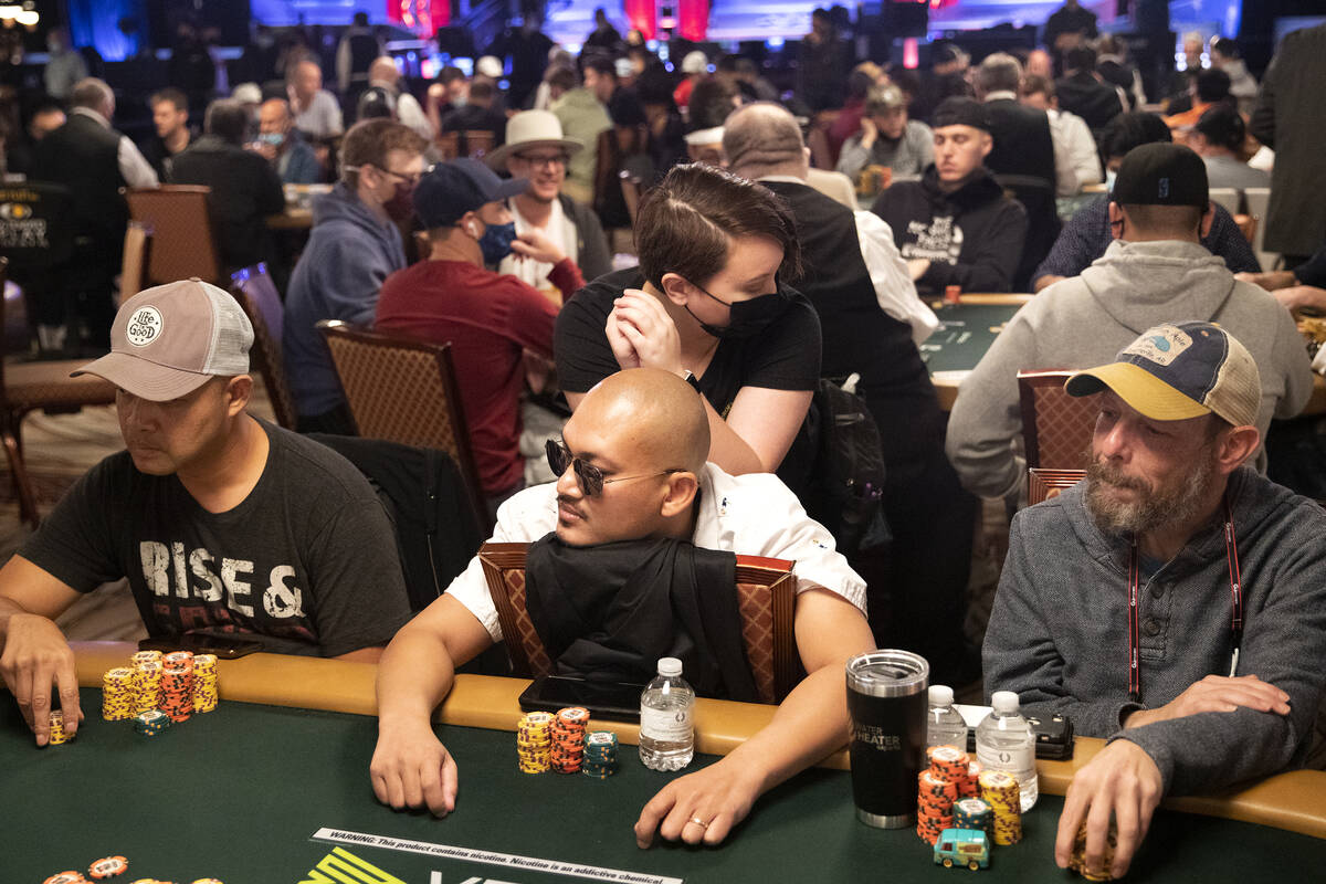 Players eye the dealer while one contender gets a massage during the World Series of Poker Main ...