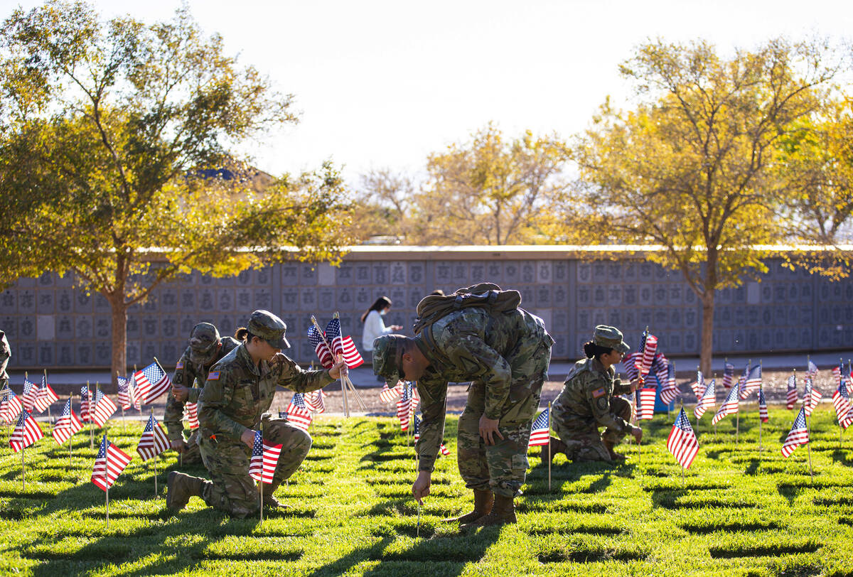 Nevada Army National Guard Sgt. April DiLiberto, left, and SFC John Foley place American flags ...