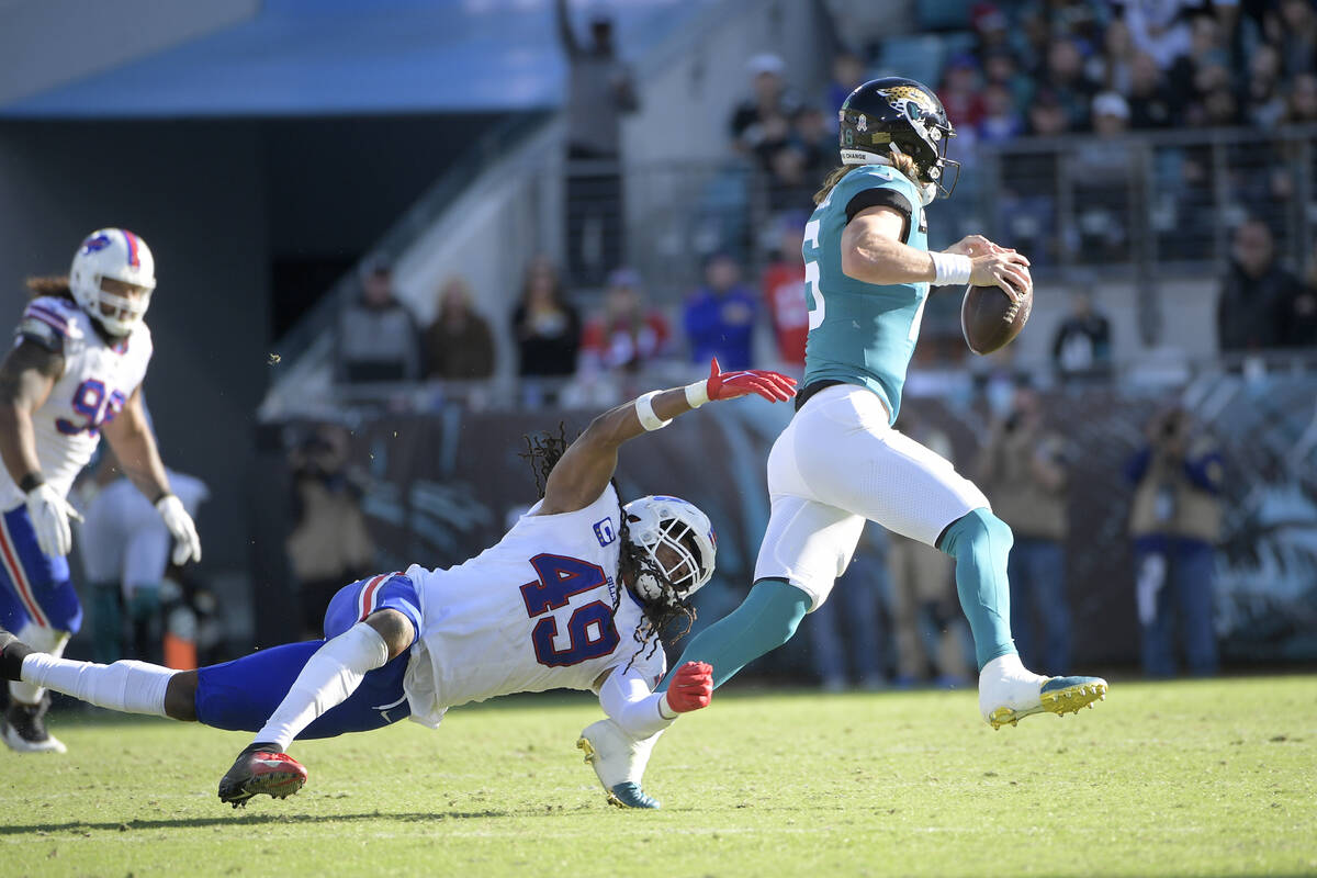 Jacksonville Jaguars quarterback Trevor Lawrence (16) scrambles away from Buffalo Bills middle ...
