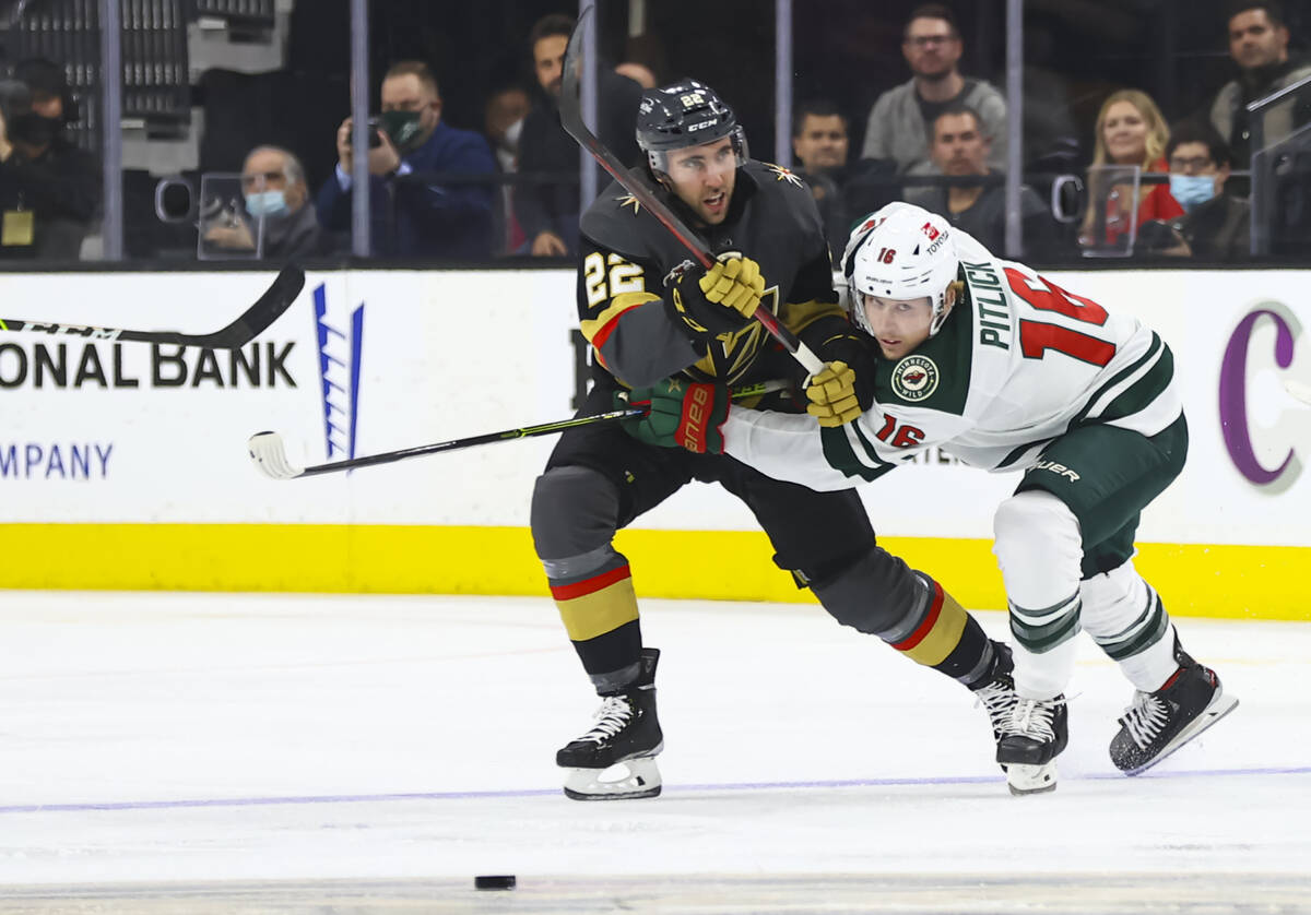 Golden Knights center Michael Amadio (22) and Minnesota Wild center Rem Pitlick (16) battle for ...